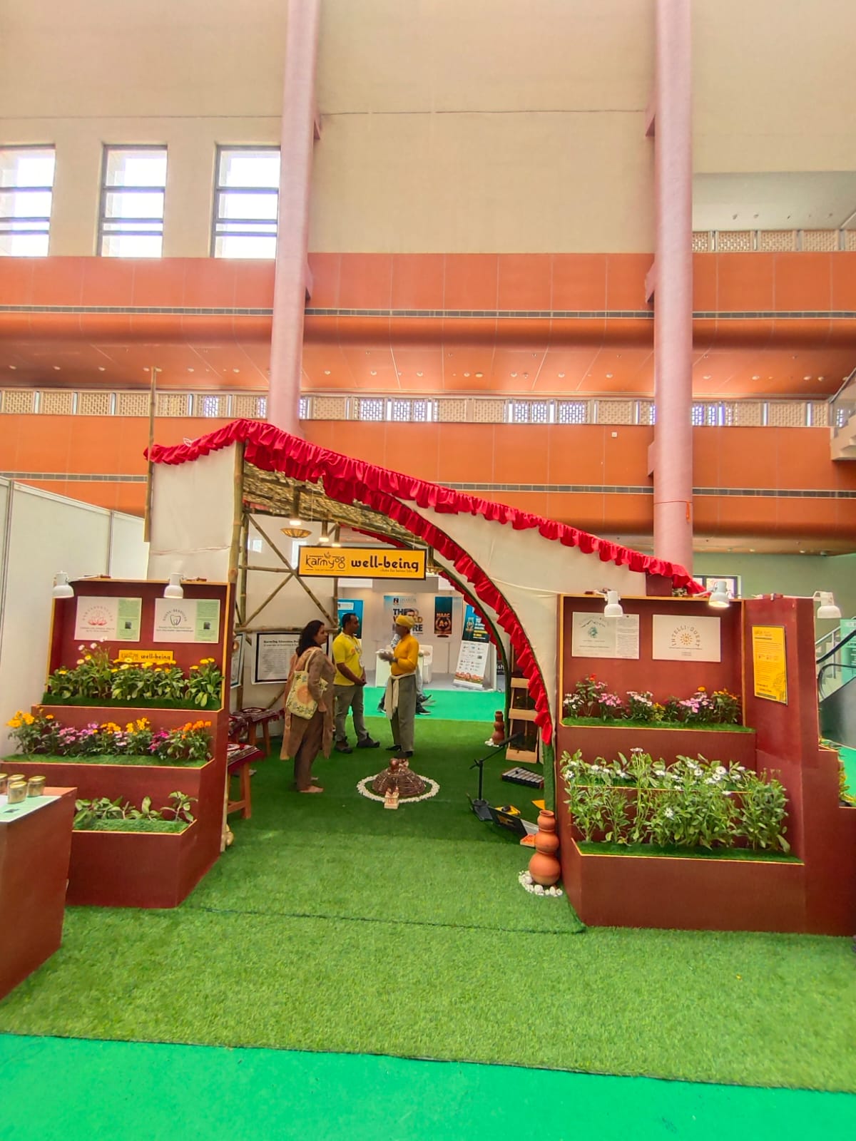 The entrance with a curved bamboo arch, red fabric, and marigold planters welcoming visitors