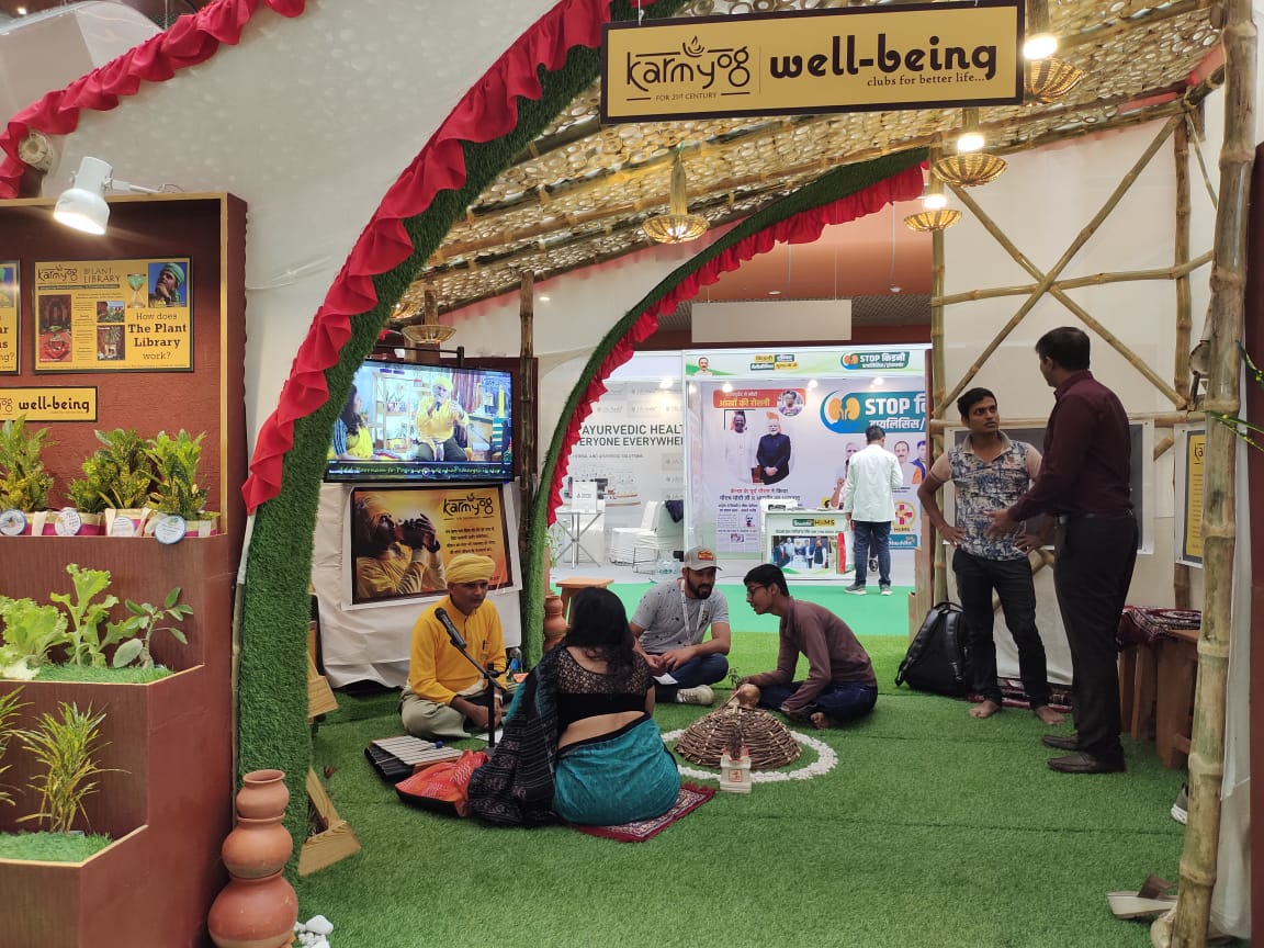 Interior view with visitors sitting informally inside the stall, bamboo framework visible overhead